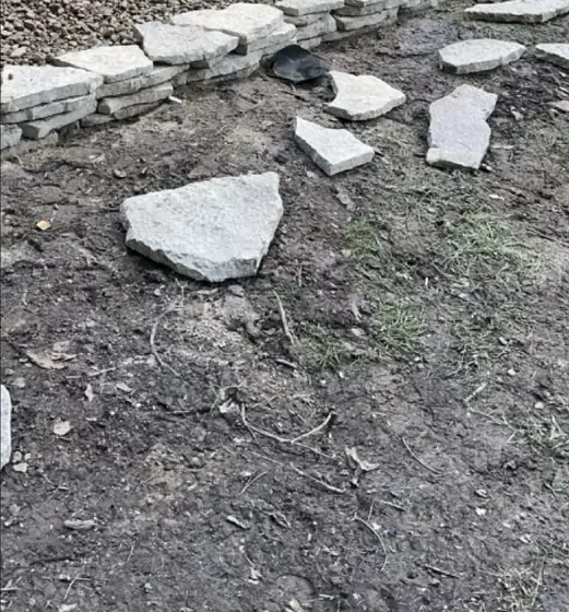 Cut stone being set as a garden border